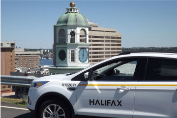 A Halifax by-law enforcement vehicle is pictured with the Halifax Citadel clock in the background.