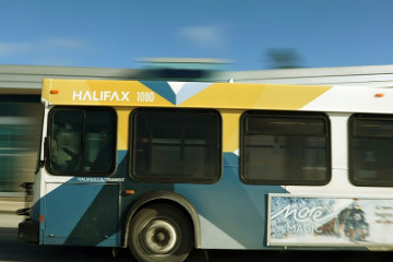 A Halifax Transit bus drives from right to left. 