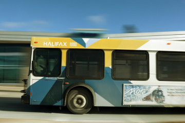 A sidelong view photograph of a Halifax Transit bus drives from right to left. 