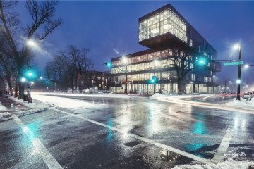 The Halifax Library Central branch at night with streetlights reflecting on the wet, winter road.