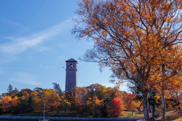 The Dingle tower is framed by the water in Northwest Arm and trees in fall colours.