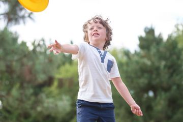 child throwing frisbee