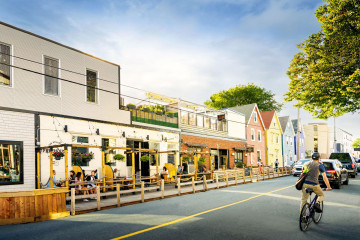 Sidewalk café on Agricola street with cyclist in street. 