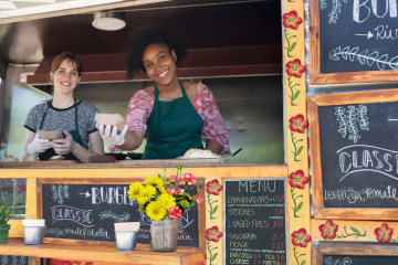 Food truck servers in window of food truck