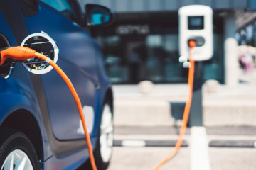 a blue electric vehicle charging at a charging station