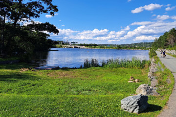 Image of Lake Micmac with cyclists on the trail running alongside.