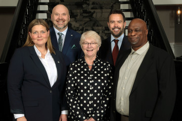 Members of North West Community Council stand together in front of the stairs inside City Hall