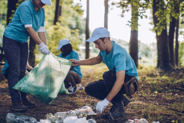 A group of community members participating in a casual park cleanup event. 