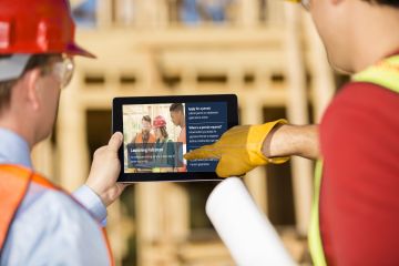 Construction workers using laptop on job site