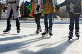 four residents ice skating on an outdoor skating rink