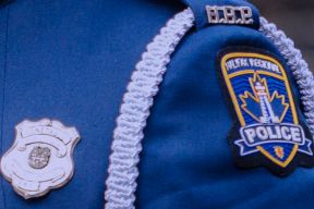 Close-up photo, taken side-on showing badge and shoulder flash on a dress tunic.