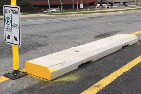 Concrete curbs used to separate people cycling from vehicle traffic on Rainnie Drive