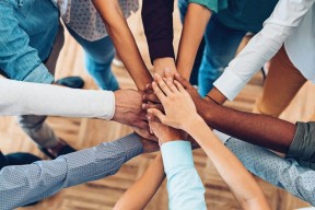 a group of people with their hands in a circle