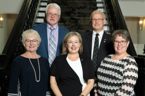 Members of Regional Council stand together in front of the stairs inside City Hall