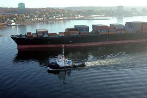 a tugboat accompanies a large container ship in the Halifax Harbour