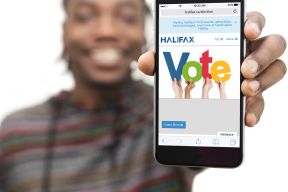 A person holds a phone, signifying that a user can e-vote in the municipal election.