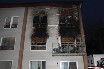 Image of an apartment building where a fire has spread up the side from several windows
