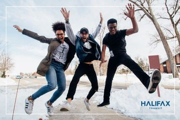 3 youth jumping in excitement on a snowy street with the Halifax Transit logo in the right, bottom corner